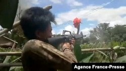 This screengrab from a video provided to AFPTV from an anonymous source and taken on May 23, 2021, shows a People's Defense Force (PDF) fighter shooting during clashes with Myanmar security forces.