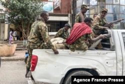 FILE - Members of the Amhara militia, that combat alongside federal and regional forces against northern region of Tigray, ride on the back of a pick up truck in the city of Gondar, on Nov. 8, 2020.