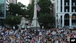 Protesters stand near a flying Confederate flag during a rally in support of its removal from the South Carolina Statehouse grounds in Columbia, June 20, 2015.