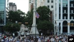 Protesters stand near a flying Confederate flag during a rally in support of its removal from the South Carolina Statehouse grounds in Columbia, June 20, 2015.