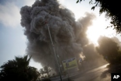 Smoke raises in the background following an Israeli airstrike hits a governmental building in Gaza City , Saturday, July 14, 2018.