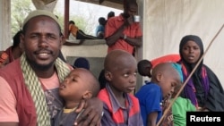 Une famille des refugiées somaliens attend un bus pour rentre dans leur pays, au Kenya, 21 janvier 2016.