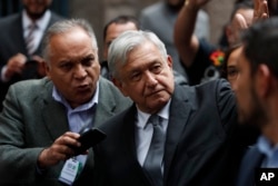 FILE - Mexico's President Andres Manuel Lopez Obrador waves as he arrives for the swearing-in ceremony for Mayor-elect Claudia Sheinbaum, in Mexico City, Dec. 5, 2018.