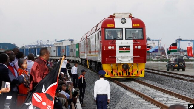 FILE - Kenyan President Uhuru Kenyatta, third from left, watches the opening of the SGR cargo train as it leaves the port containers depot in Mombasa to Nairobi, May 30, 2017. The project, a $3.3 billion investment backed by China, is the country's largest infrastructure project.