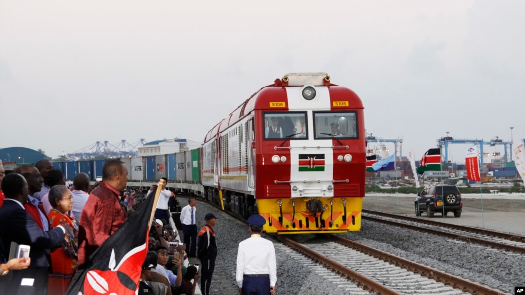 资料照片：时任肯尼亚总统肯雅塔(左三)出席开通仪式，观看标轨铁路集装箱货运列车离开蒙巴萨的港口集装箱库区驶往内罗毕。(2027年5月30日)(photo:VOA)