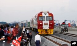 FILE - Kenyan President Uhuru Kenyatta (3rd-L) watches the opening of the SGR cargo train as it leaves the port containers depot in Mombasa to Nairobi, May 30, 2017. The project, a $3.3 billion investment backed by China, is the country's largest infrastructure undertaking since independence.