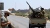 Les forces de sécurité libyennes patrouillent près du site d'une attaque contre un poste de contrôle dans la ville de Zliten, à 170 km à l'est de la capitale Tripoli, le 23 août 2018.
