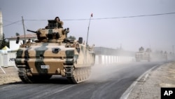 Tank-tank dan kendaraan lapis baja tentara Turki bergerak menuju perbatasan Suriah, Karkamis, di Turki (25/8). (AP/Halit Onur Sandal)