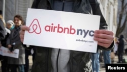 FILE- Supporters of Airbnb stand during a rally before a hearing called "Short Term Rentals: Stimulating the Economy or Destabilizing Neighborhoods?" at City Hall in New York, Jan. 20, 2015. 