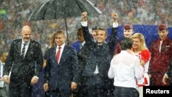 Tổng thống Kolinda Grabar-Kitarovic an ủi huấn luyện viên đội Croatia Zlatko Dalic dưới trời mưa.