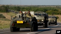 Russian military vehicles maneuver on a road 15 kilometers (9 miles) from the Ukrainian border in the Rostov-on-Don region, Russia, Aug. 15, 2014.