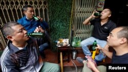 FILE - Men drink Sabeco's Saigon beer at a roadside restaurant in Hanoi, Vietnam, Nov. 29, 2017.