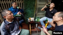 FILE - Men drink Sabeco's Saigon beer at a roadside restaurant in Hanoi, Vietnam, Nov. 29, 2017. (REUTERS/Kham)