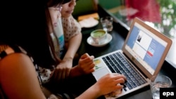 Two women use social networking site Tumblr in a cafe in Hanoi. (File)