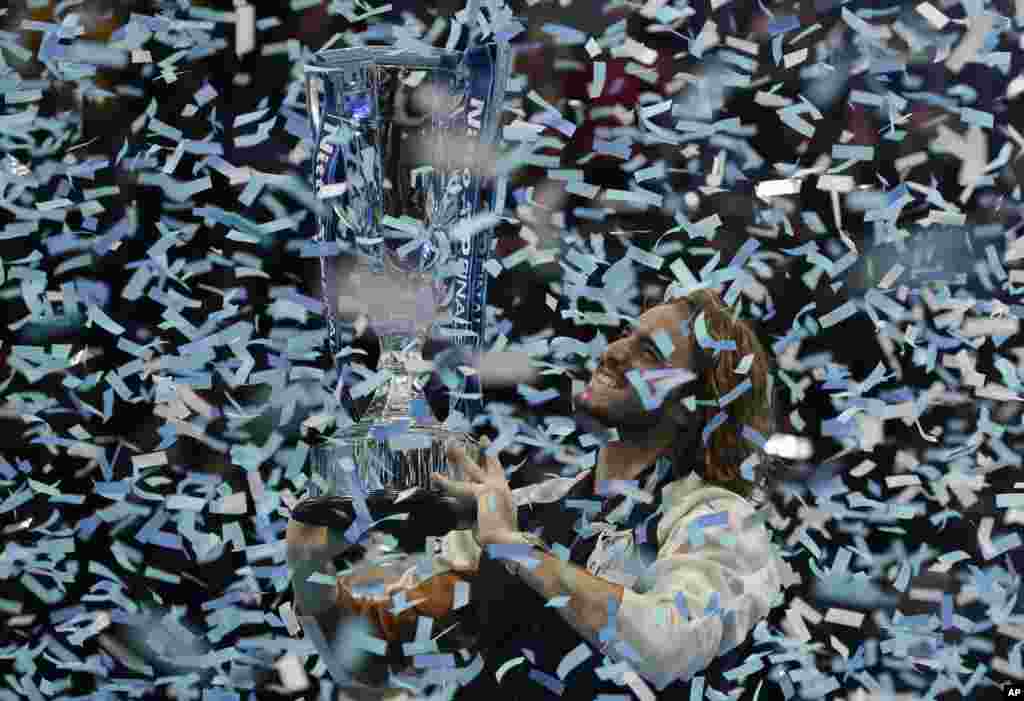 Stefanos Tsitsipas of Greece holds up a trophy and celebrates as confetti falls after defeating Austria's Dominic Thiem in the final of the ATP World Finals tennis match at the O2 arena in London, Nov. 17, 2019.