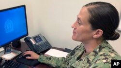 U.S. Navy Legalman First Class Tamatha Schulmerich works at her desk at the Naval War College, Wednesday, July 11, 2018, in Newport, R.I. (AP Photo/Jennifer McDermott)