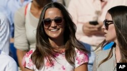 FILE - Pippa Middleton, left, the sister of Kate, the Duchess of Cambridge, watches the quarterfinal tennis match between Canada's Milos Raonic and France's Gilles Simon on the fifth day of the Queen's Championships in London. 