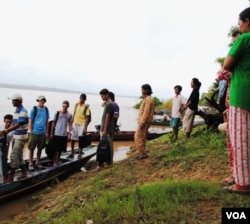 Locals on a Mekong inland at Sambor, Kratie province see off foreign tourists. A proposed mega hydrodam at the site would completely inundate the island if constructions go ahead.