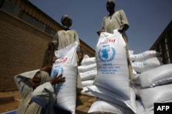 FILE - Sacs of sorghum are stored following the delivery of nearly 50,000 tonnes of US food aid bound for areas of Sudan affected by conflict, on May 26, 2015. in Port Sudan.