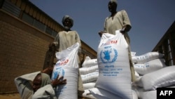 FILE - Sacs of sorghum are stored following the delivery of nearly 50,000 tonnes of US food aid bound for areas of Sudan affected by conflict, on May 26, 2015. in Port Sudan. T