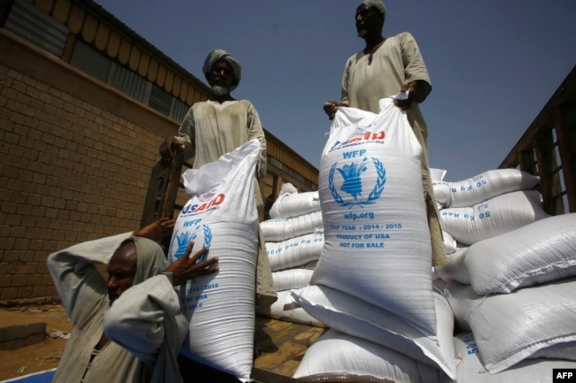 FILE - Sacs of sorghum are stored following the delivery of nearly 50,000 tonnes of US food aid bound for areas of Sudan affected by conflict, on May 26, 2015. in Port Sudan.