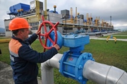 FILE - A worker at a Ukrainian gas station in Volovets, western Ukraine, adjusts a valve, Oct. 7, 2015.