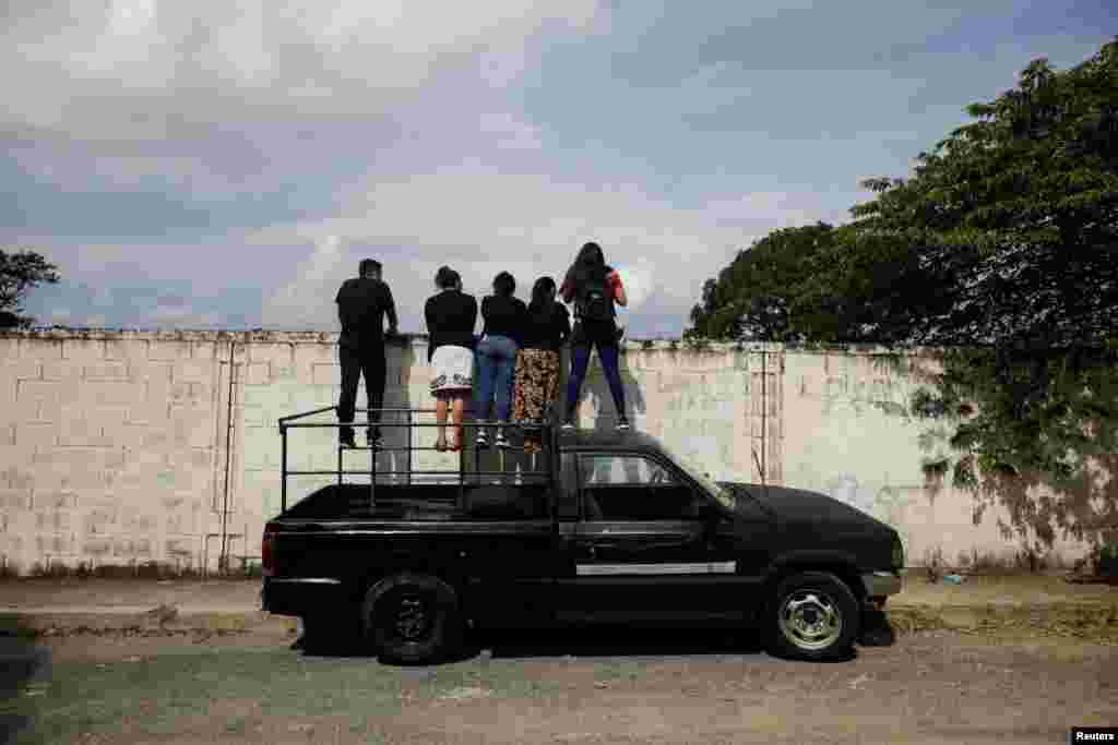 A family watches the funeral of a relative&nbsp;at La Bermeja cemetery in San Salvador, El Salvador, under the coronavirus disease (COVID-19) measures, as the coronavirus continues to spread, July 27, 2020.