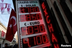 FILE - A board showing the currency exchange rates of the U.S. dollar and the Euro against Turkish lira is on display at a currency exchange office in Istanbul, Jan. 12, 2017.