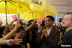 Occupy Central pro-democracy movement founder Chan Kin-man (2nd R) greets supporters as he arriving at the court for sentencing, in Hong Kong, Apr. 24, 2019.
