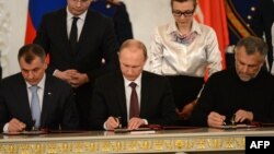 Presiden Rusia Vladimir Putin (tengah) dan para pemimpin Krimea menandatangani kesepakatan di Moskow hari Selasa (18/3). 