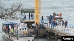 Russian Emergencies Ministry members work at a quay of the Black Sea near the crash site of Russian military Tu-154 plane, in the Sochi suburb of Khosta, Russia, Dec. 25, 2016. 