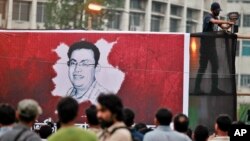 FILE - A Bangladeshi activist sets up a light on a poster displaying a portrait of slain Bangladeshi-American blogger Avijit Roy in Dhaka, Bangladesh, Feb. 27, 2015.