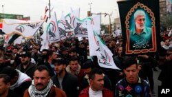 Hundreds rally on the second anniversary of the assassination of Iranian Gen. Qassim Soleimani, chanting anti-American slogans in the streets of Baghdad, Jan. 1, 2022.