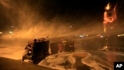 Lebanese anti-government protesters are sprayed by water cannons during a protest in Beirut against the ongoing trash crisis and government corruption, Oct. 8, 2015.