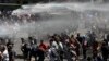 Manifestantes son rociados con un cañón de agua por la policía durante una protesta en Santiago, Chile, el miércoles 23 de octubre de 2019. Foto: AP.
