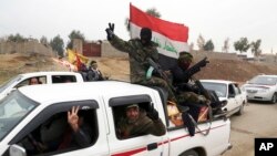 Shi'ite fighters of the Popular Mobilization Forces patrol in a neighborhood recently liberated from Islamic State militants in the eastern Mosul, Iraq, Jan. 25, 2017.