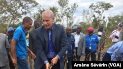 L'ambassadeur des Etats-Unis, Todd Haskell tient une houe sur le chantier de route à Missie-Missie, dans le district de Mindouli, Congo-Brazzaville, 23 octobre 2018. (VOA/Arsène Sévérin)