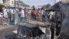 People gather at the scene of a car bomb explosion, at the central market, in Maiduguri, Nigeria, Tuesday, July 1, 2014. A car bomb exploded in a market in Nigeria’s northeastern city of Maiduguri on Tuesday morning, and dozens of people are feared dead, 