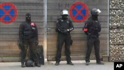 This framegrab taken from APTN shows armed police officers during a raid in the Molenbeek neighborhood of Brussels, Belgium, Friday March 18, 2016. (APTN via AP)