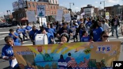 Activistas marchan en Boston, en esta foto de archivo del 1 de mayo de 2018, para protestar por la cancelación del TPS a inmigrantes y pedir aumento del salario mínimo. Foto[ AP/Steven Senne.