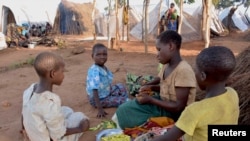 FILE - Mozambican child refugees prepare food at Kapise camp in Malawi's Mwanza district, Jan. 18, 2016.