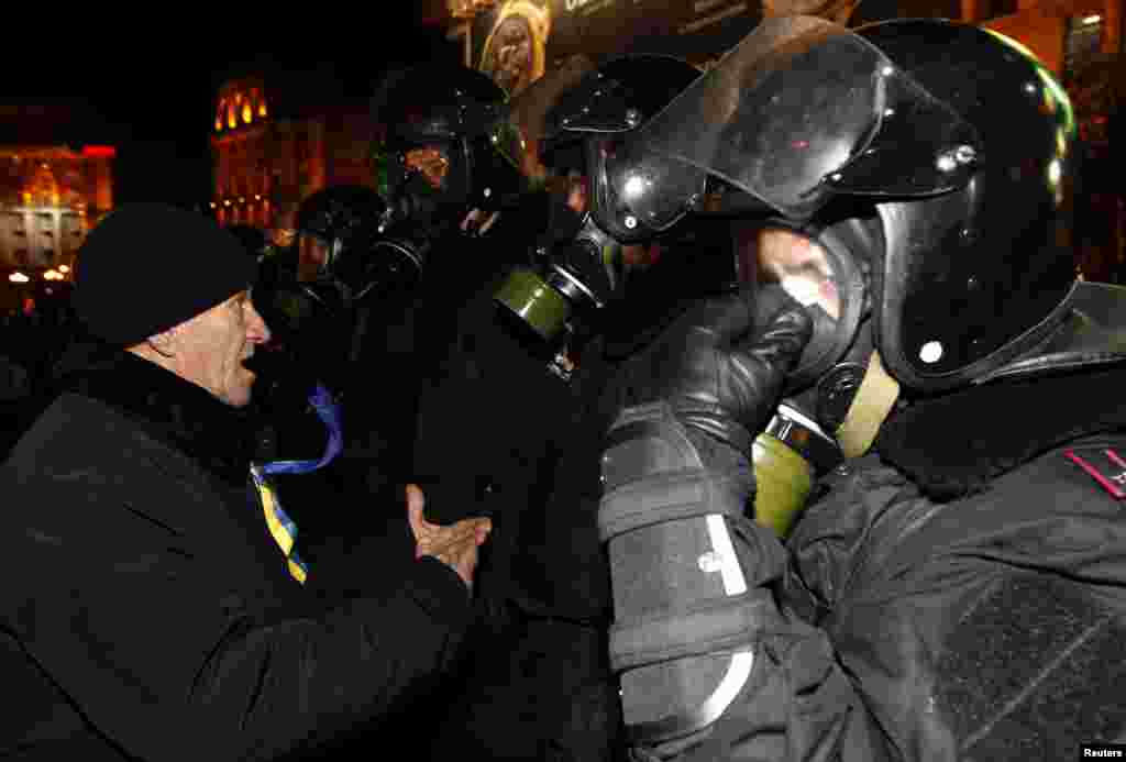 Police stand guard in front of protesters during a demonstration in support of EU integration at Independence Square in Kyiv Nov. 29, 2013. 