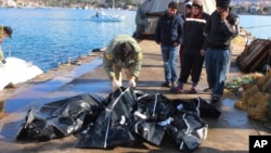 People check bodies of migrants that were drowned as they were trying to reach Greece, at a port near Izmir, Turkey, Jan. 21, 2016. 