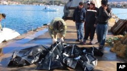 People check bodies of migrants that were drowned as they were trying to reach Greece, at a port near Izmir, Turkey, Jan. 21, 2016. 