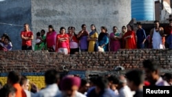 People gather at the site of an accident after a train traveling at high speed ploughed through a crowd of people on rail tracks near Amritsar, India, Oct. 20, 2018.