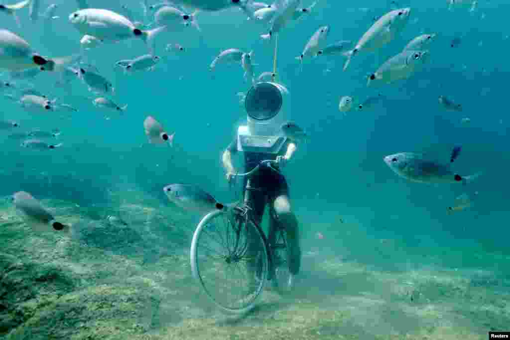 A woman pretends to ride a bike in Underwater Park in Pula, Croatia, Aug. 1, 2017.