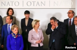 German Defense Minister Ursula von der Leyen (C) talks with Greek Defense Minister Panos Kammenos (2nd R) at a family photo during a NATO defense ministers meeting at the Alliance's headquarters in Brussels, Belgium Feb. 10, 2016.