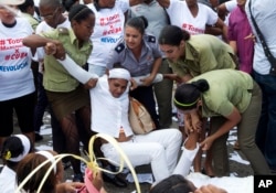 Polisi menyeret aktivis HAM Kuba dari kelompok Ladies in White yang berdemonstrasi menuntut pembebasan tahanan politik, di Havana, Kuba (20/3).