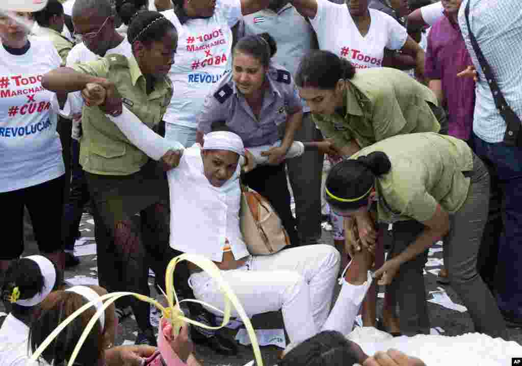 Polisi menyeret aktivis HAM Kuba dari kelompok Ladies in White yang berdemonstrasi menuntut pembebasan tahanan politik, di Havana, Kuba (20/3). (AP/Rebecca Blackwell)
