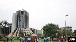 Quelques personnes près du siège de la chaîne de télévision nationale Radiodiffusion Télévision Gabonaise (RTG) lors de la tentative de coup d’Etat à Libreville, Gabon, 7 janvier 2019,.